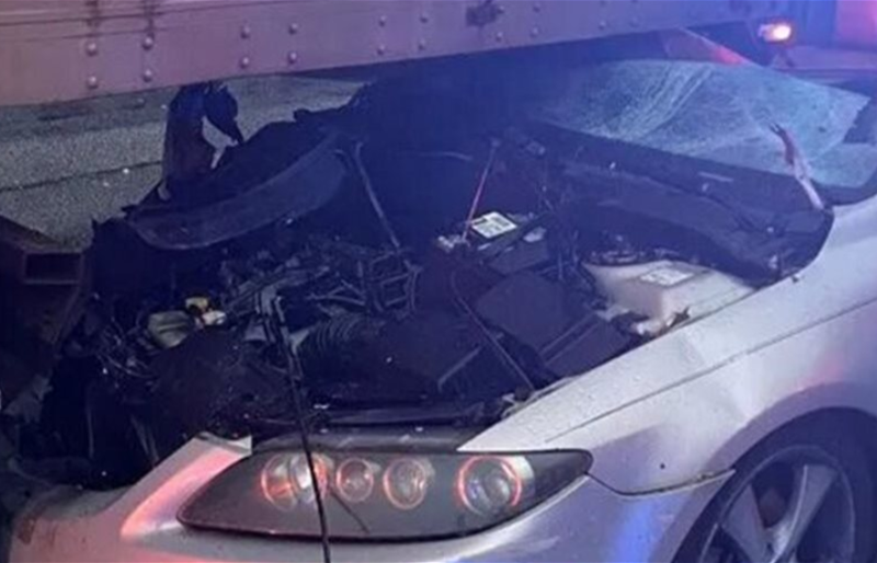 سائق ينجو بأعجوبة بعد انزلاق سيارته أسفل شاحنة في كارولتون بسبب الانشغال بالهاتف